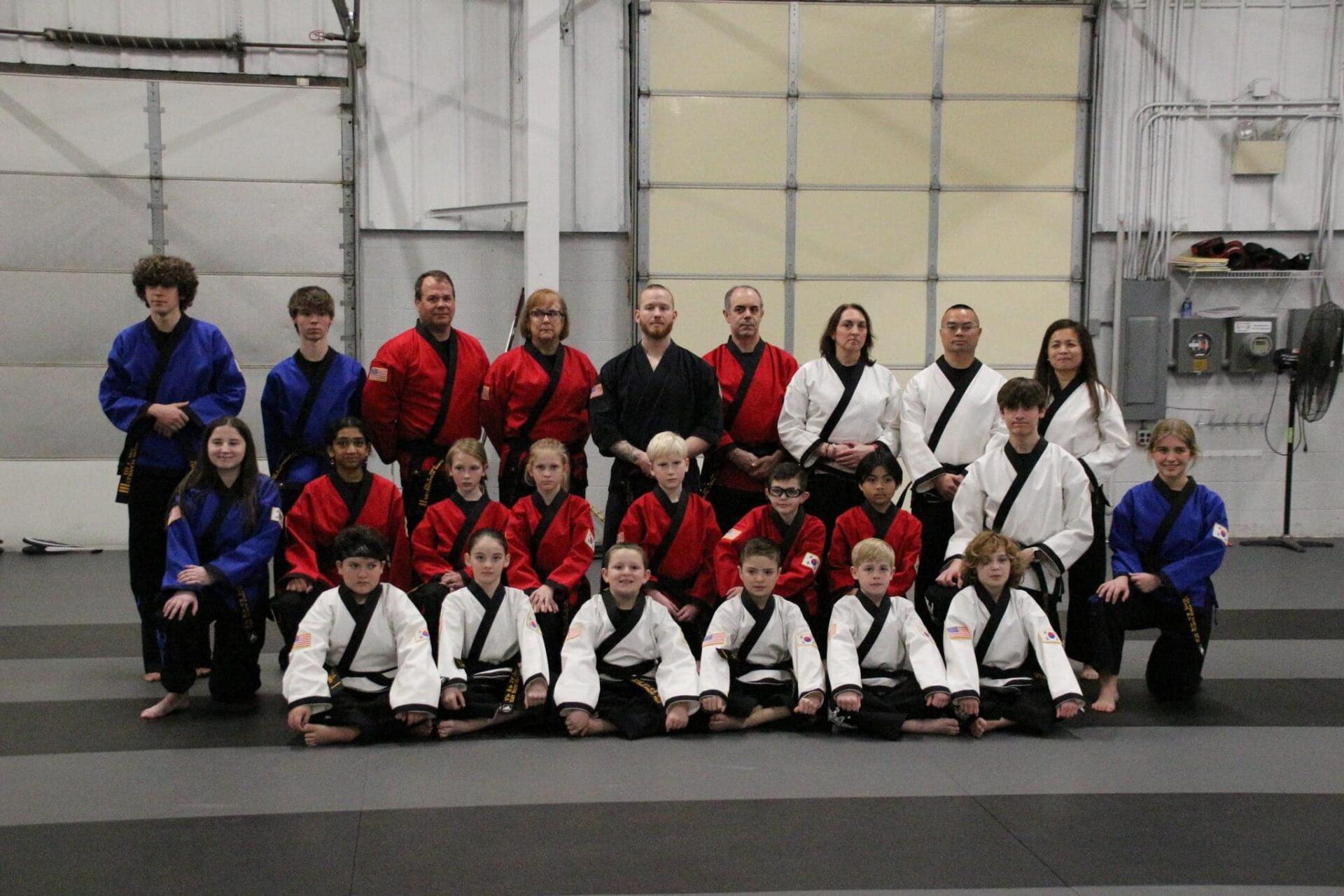 428648020_896638772467781_8966171967561376159_n a group of people, both children and adults, dressed in karate uniforms and posing for a picture